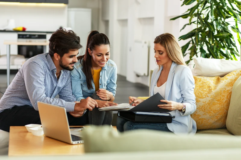 Young couple seating down with a loan officer.